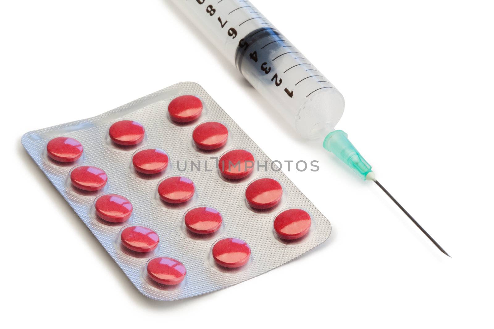 Blister strip and syringe on a white background