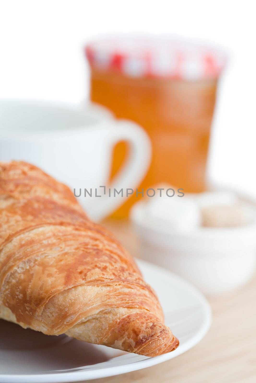 Breakfast with coffee marmalade and croissants on a white background