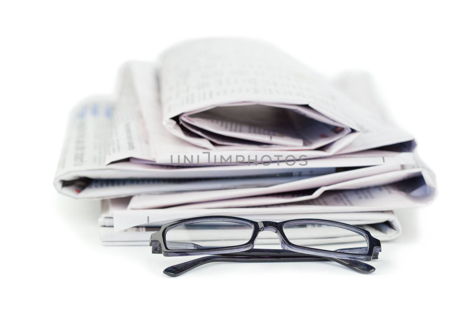 Newspapers and black glasses on a white a background