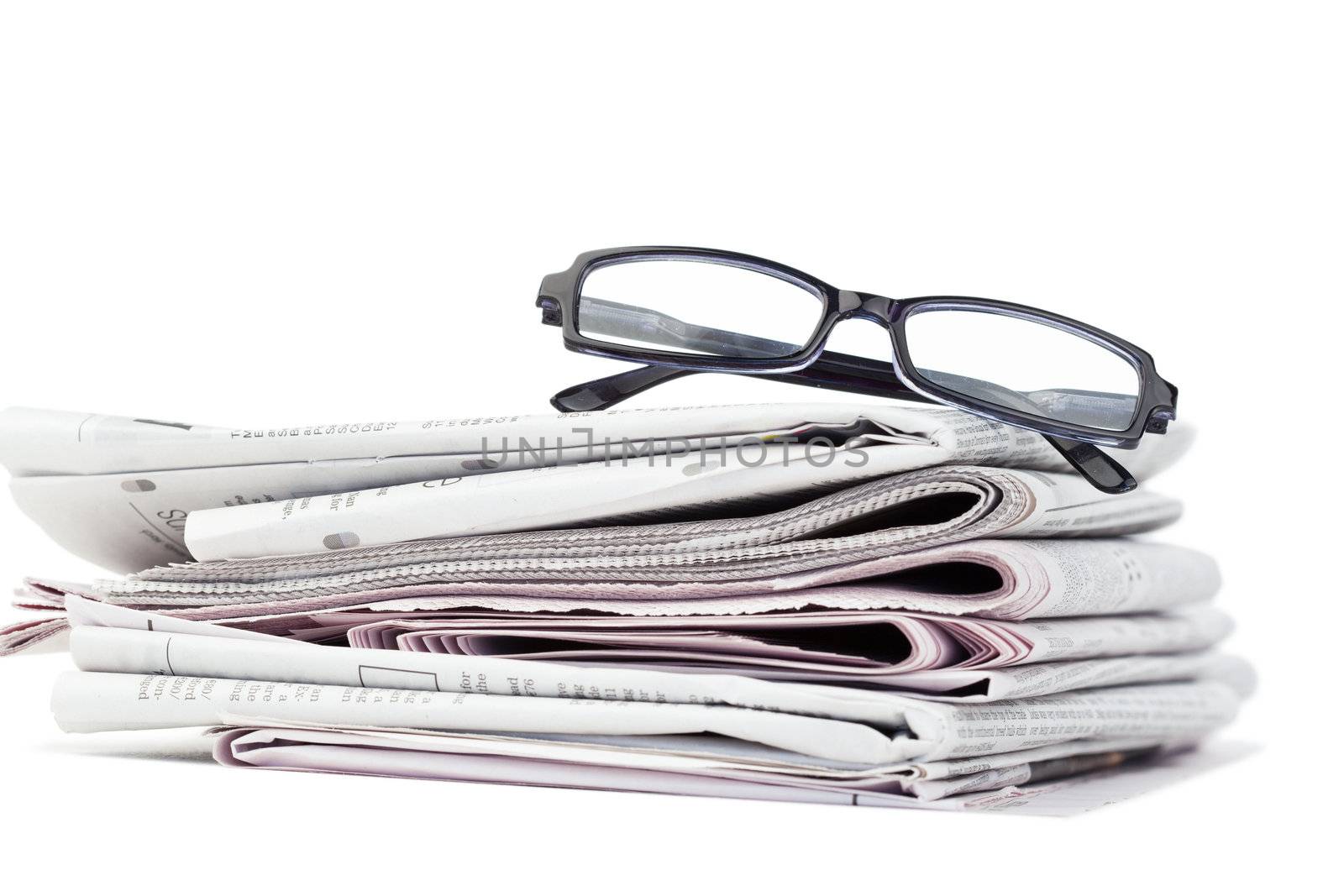 Newspapers and black glasses by Wavebreakmedia