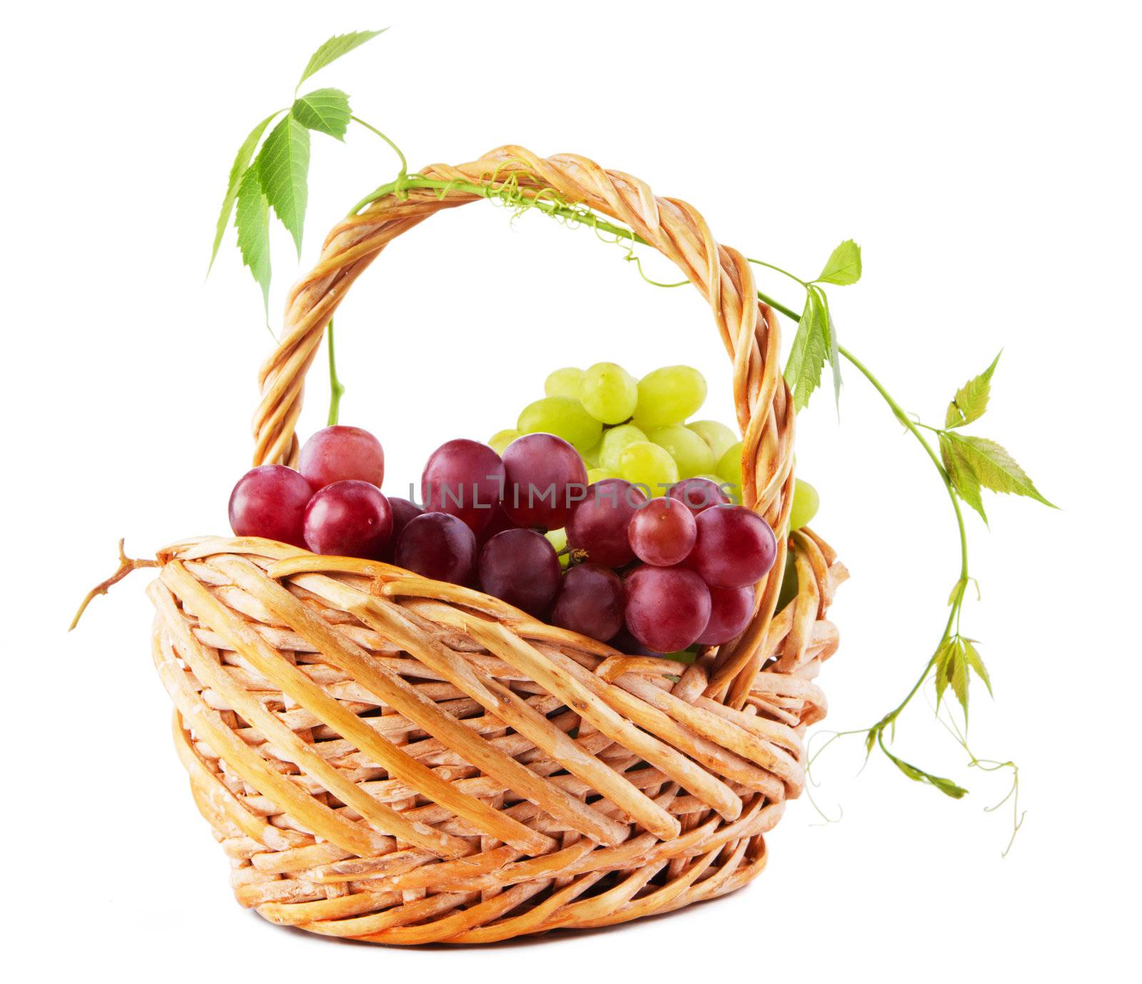 Wicker basket with grapes isolated on white background