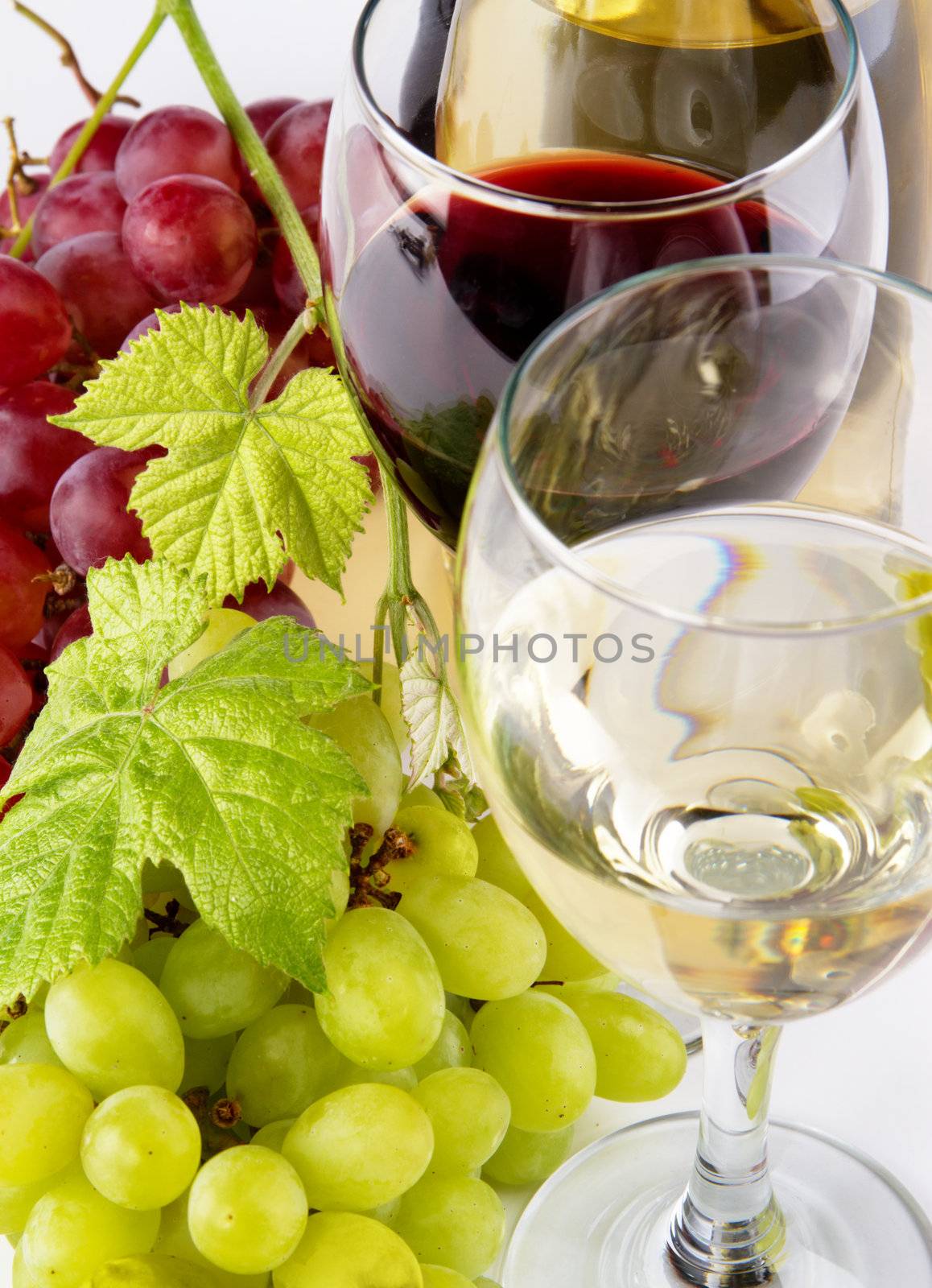 Red and white wine, with bunches of grapes, closeup photo