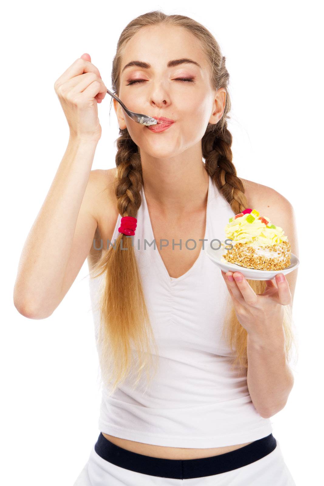 Young lady tasting a cake, studio portrait