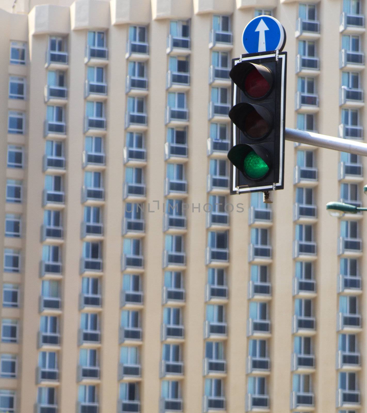 Road lights showing green, with skyscraper on background