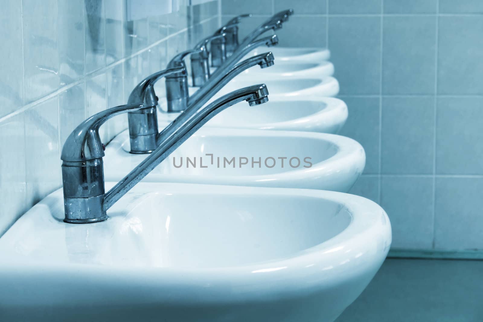 Row of wash sinks in public bathroom