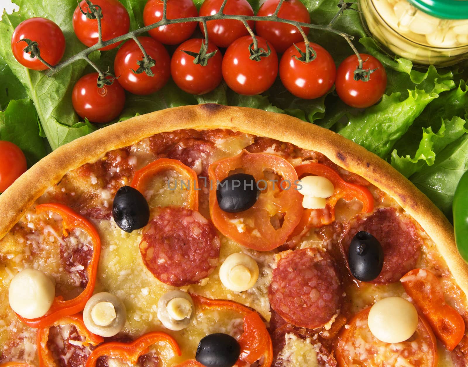 Closeup picture of a pizza with vegetables and cherry tomatoes