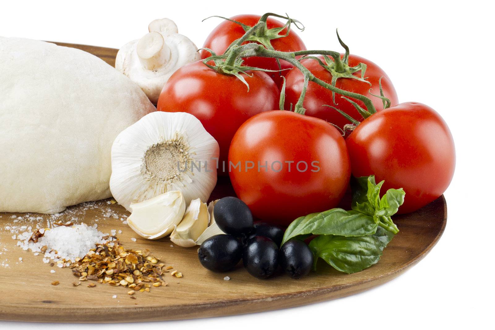 Close-up cropped shot of vegetables and other pizza ingredients on wooden plank.