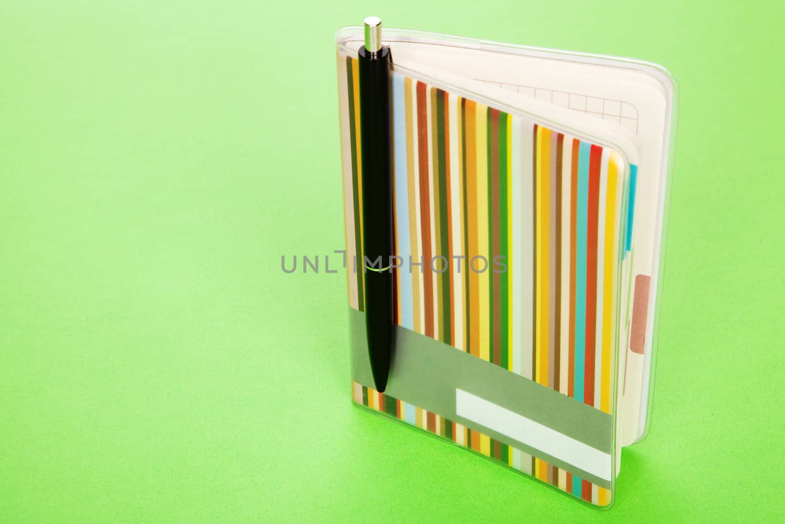 Colorful notepad on green background