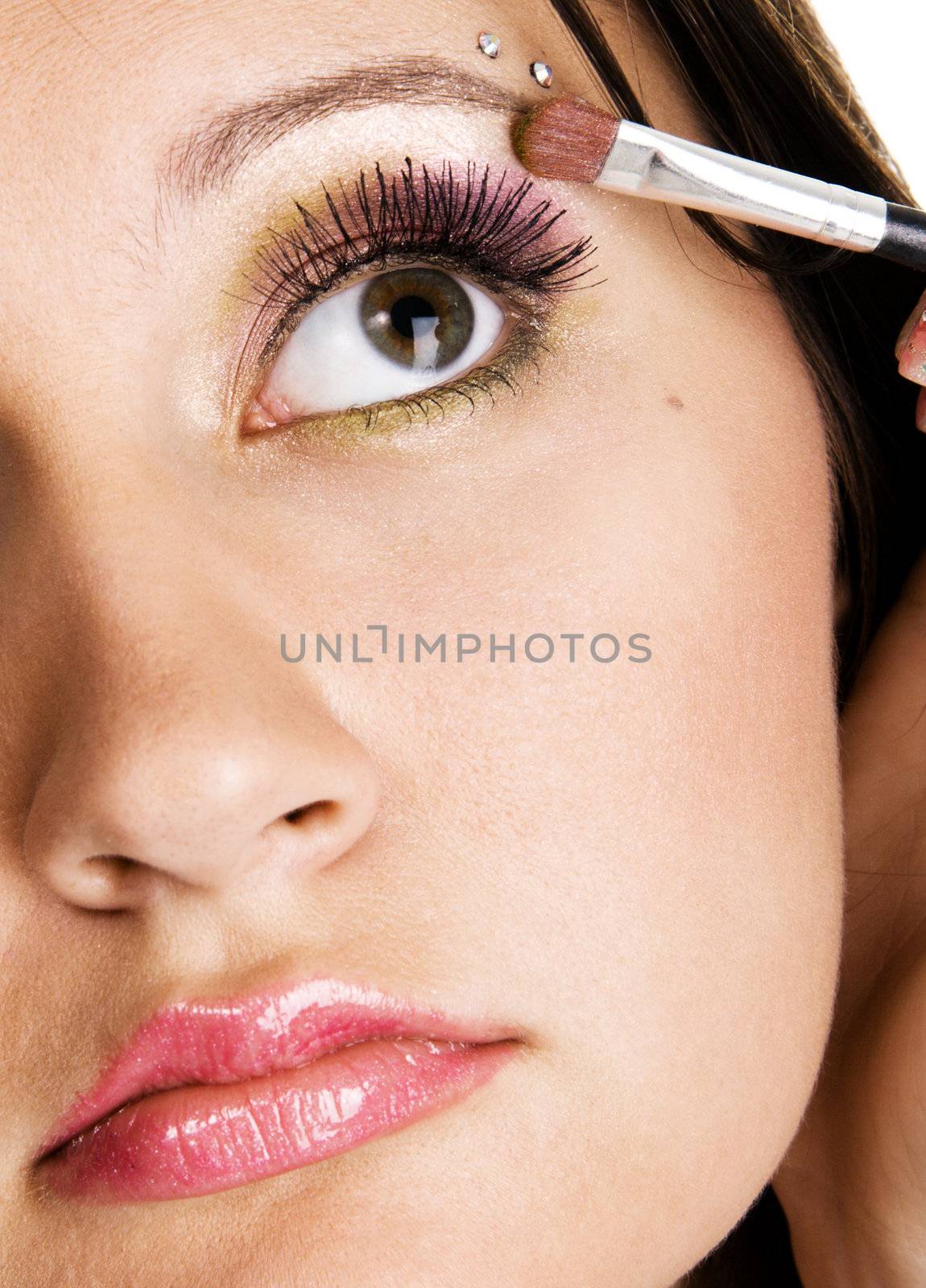 Beautiful young woman applying makeup, closeup photo