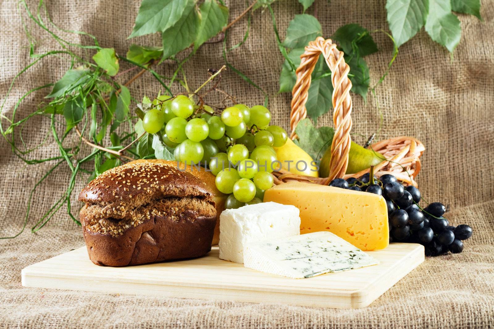 Bread, cheese and grapes still life, studio photo