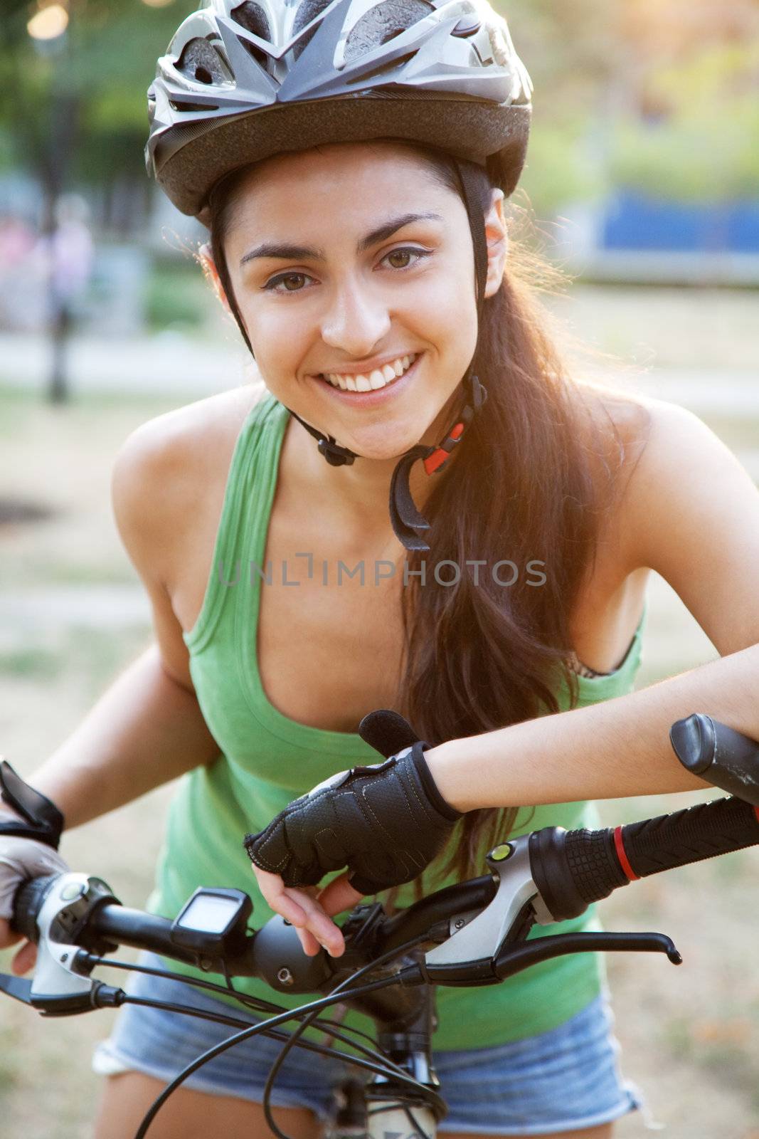 Beautiful young woman riding a bicycle by Gdolgikh