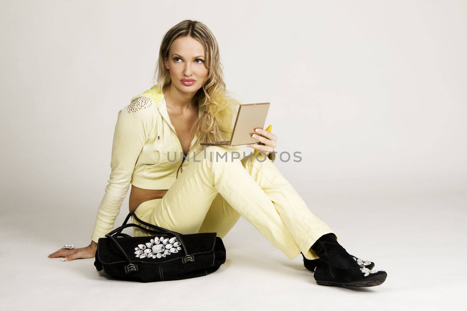 Fashioable young woman holding makeup accessories