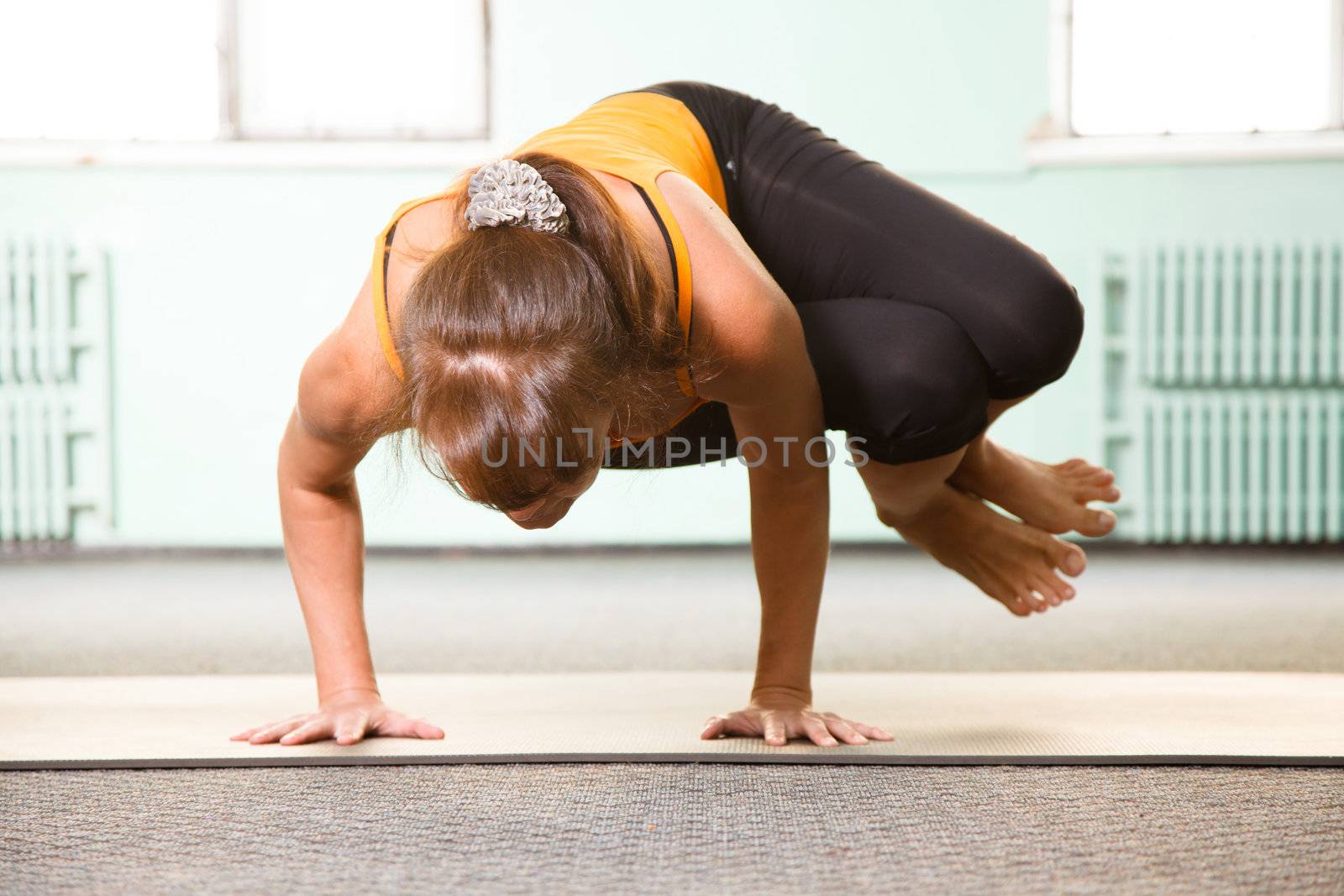 Mature woman exercising yoga in a gym