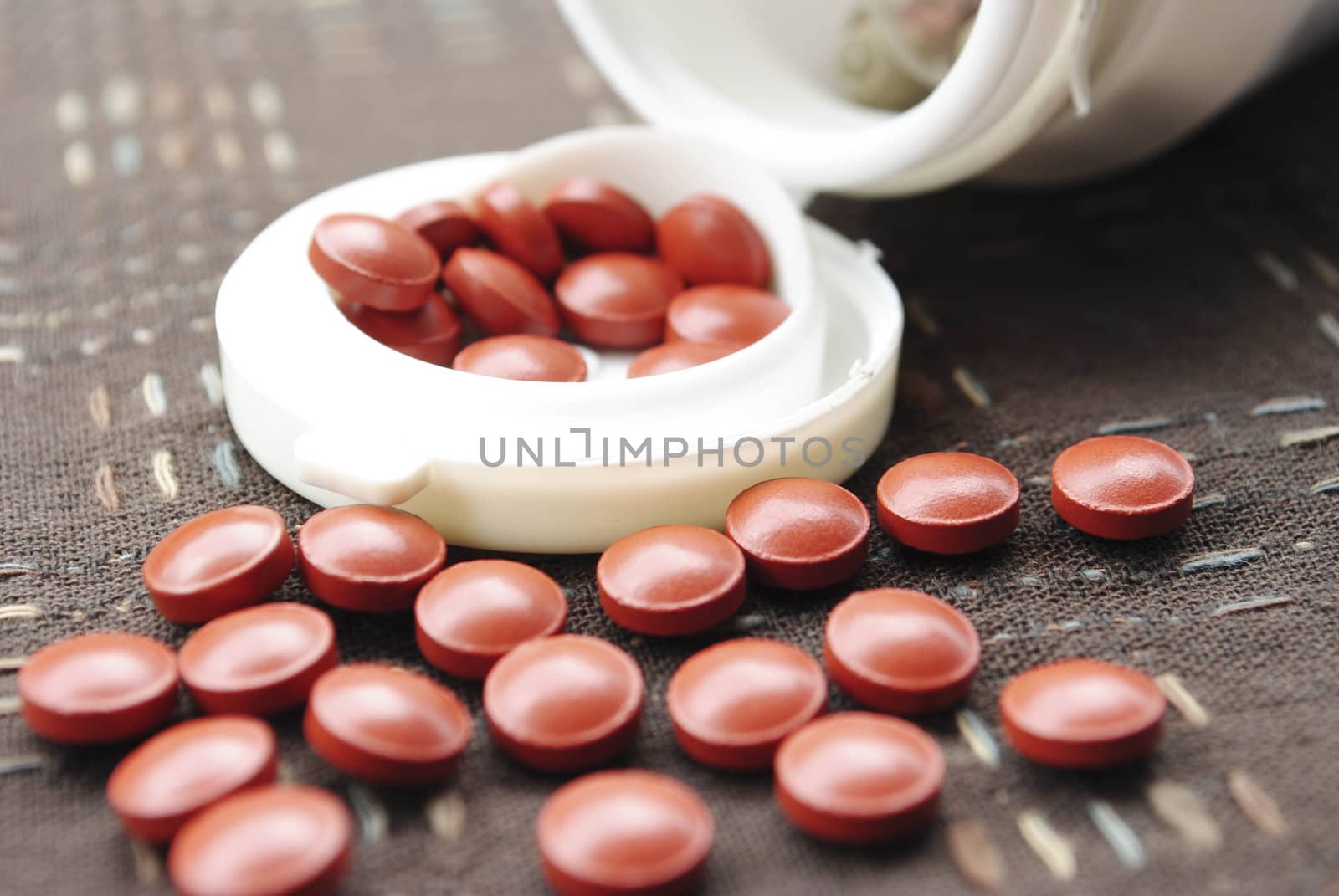 Vitamin pills an pill bottle on white background