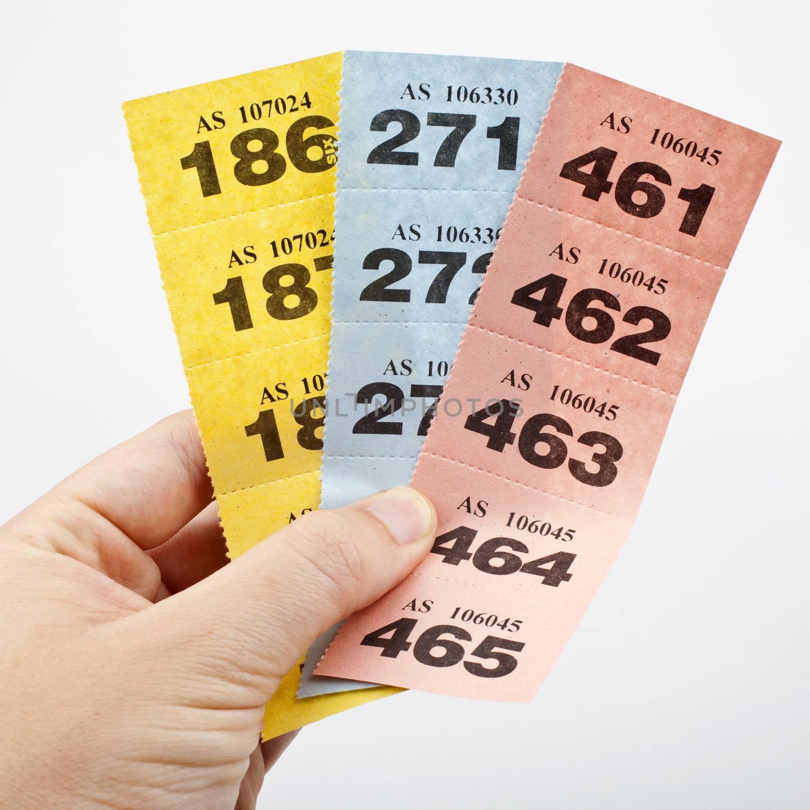 Hand holding three strips of Raffle tickets.