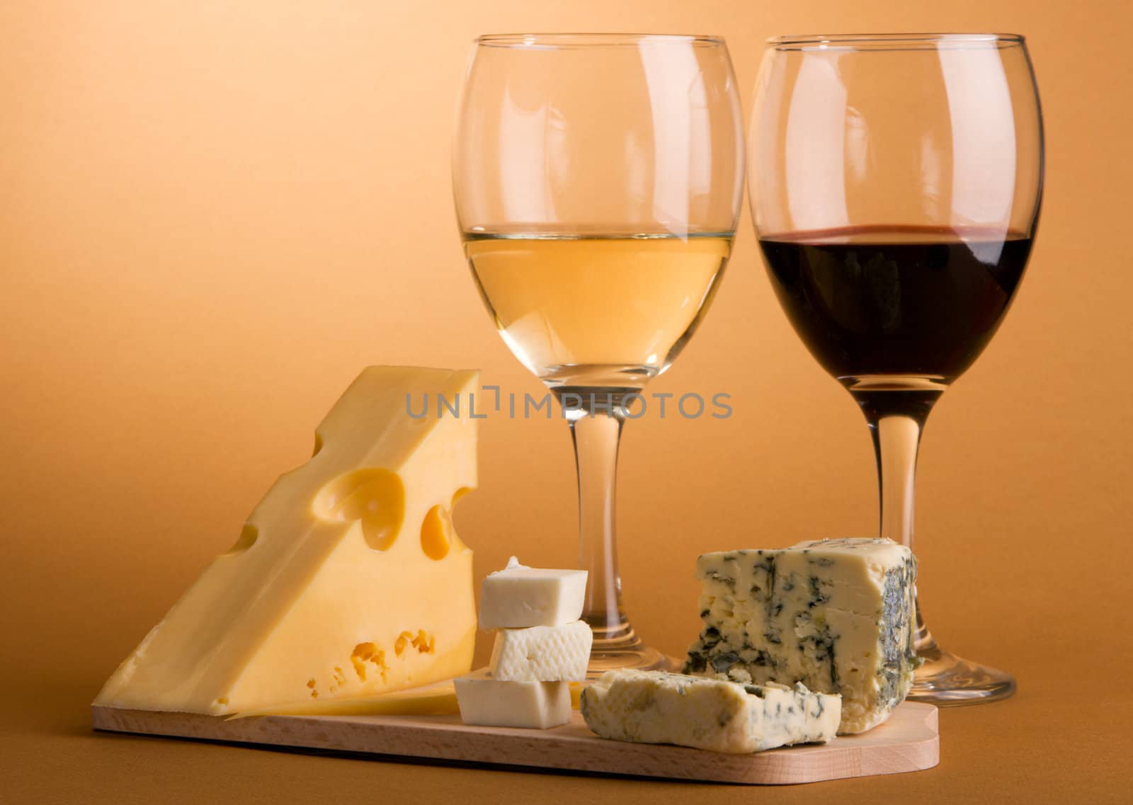 Wine and cheese over brown background still-life photo