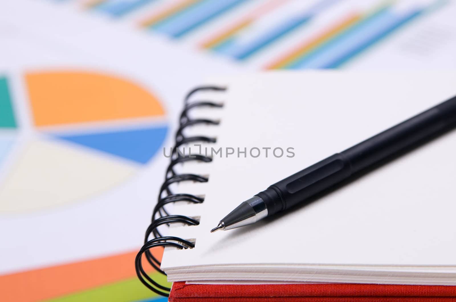 Close-up photo of a notebook and pen by Gdolgikh