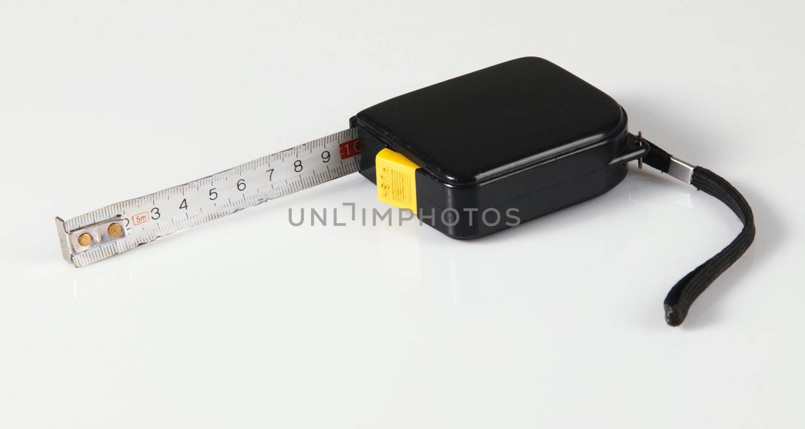 Tape measure on neutral background, closeup photo