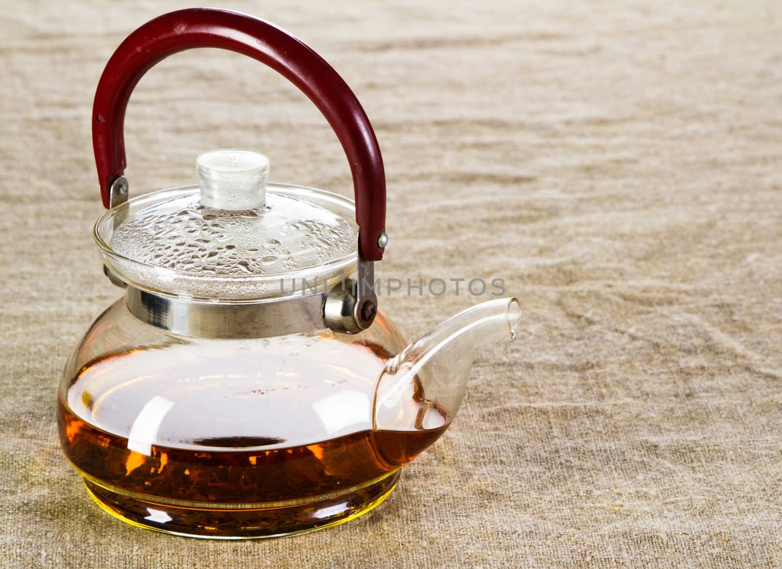 Tea pot on a rough cloth studio photo