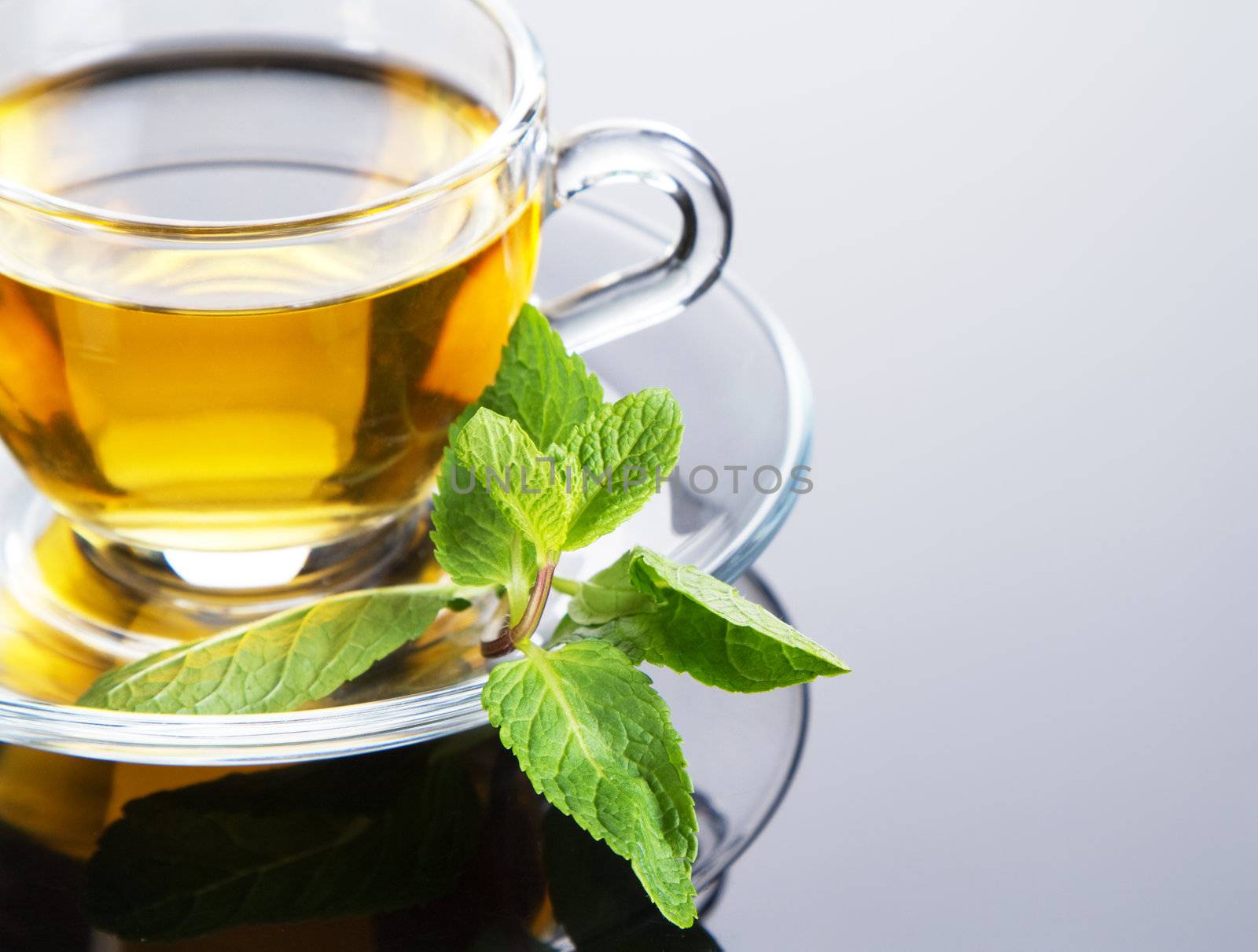 Tea cup with fresh mint leaves, closeup photo