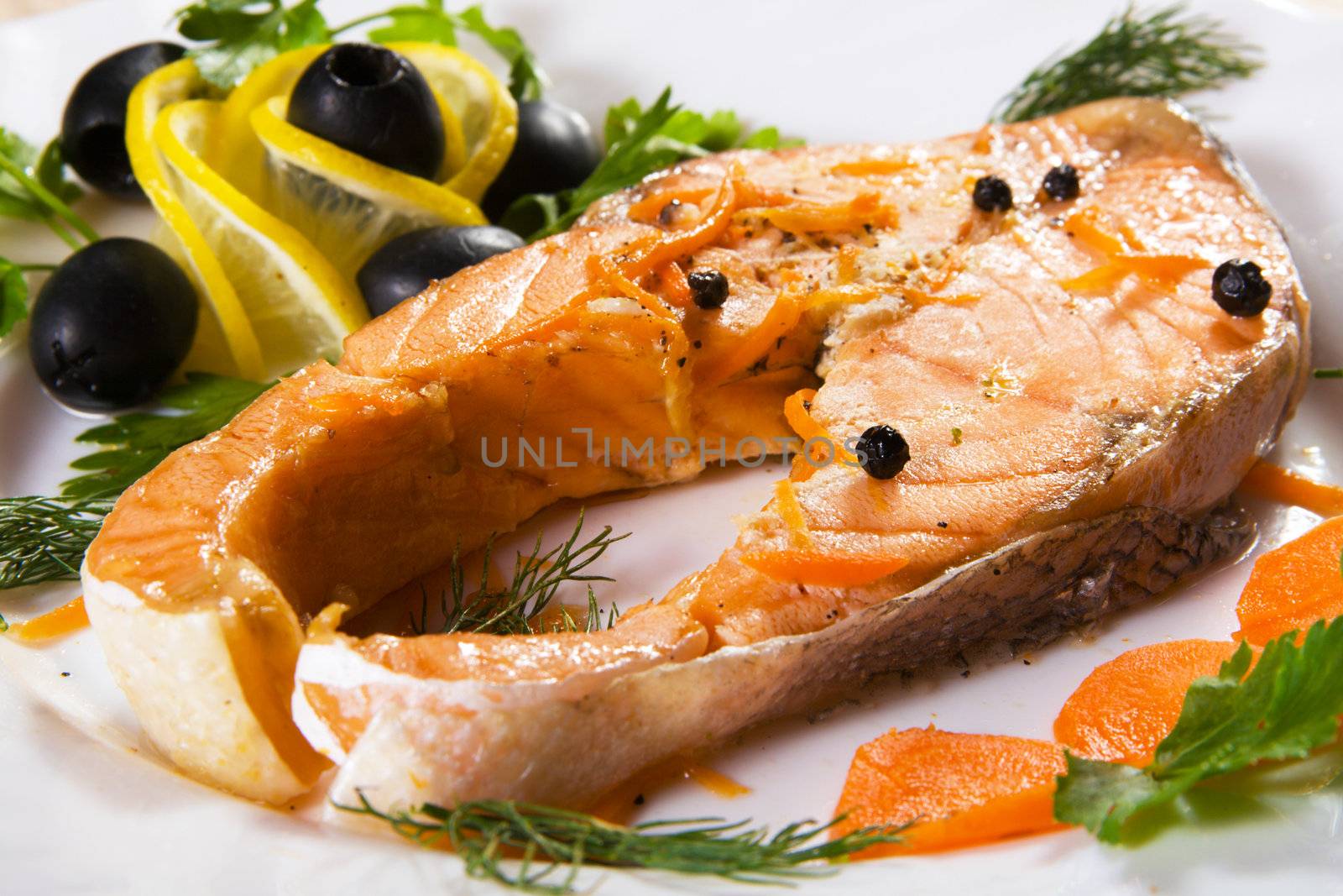 Salmon served with olives and lemon closeup photo