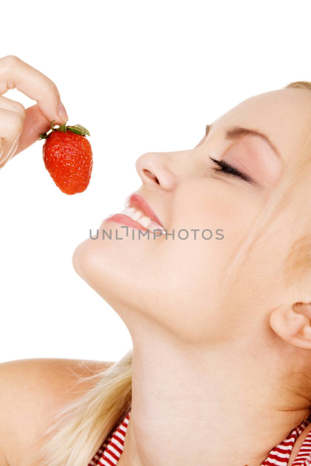 Beautiful girl tasting a strawberry, face portrait