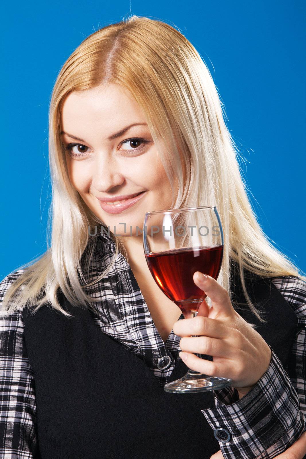 Young woman with a glass of red wine, blue background