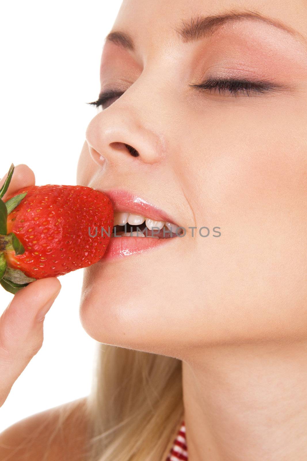 Beautiful girl tasting a strawberry, face portrait