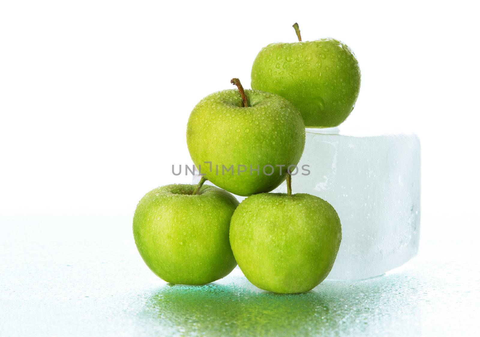 Green apples on ice cube, studio still life