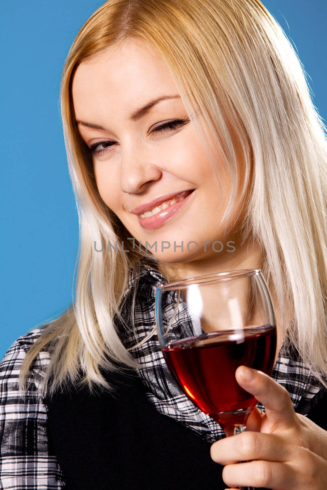 Young woman with a glass of red wine, blue background