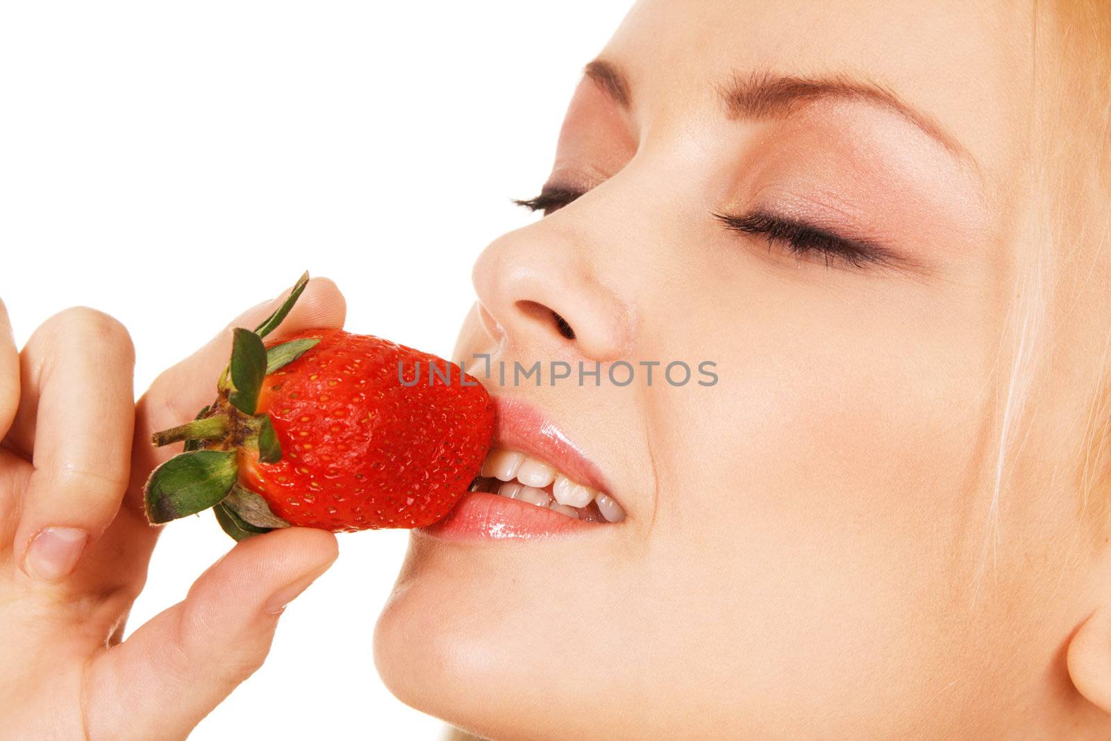 Beautiful girl tasting a strawberry, face portrait