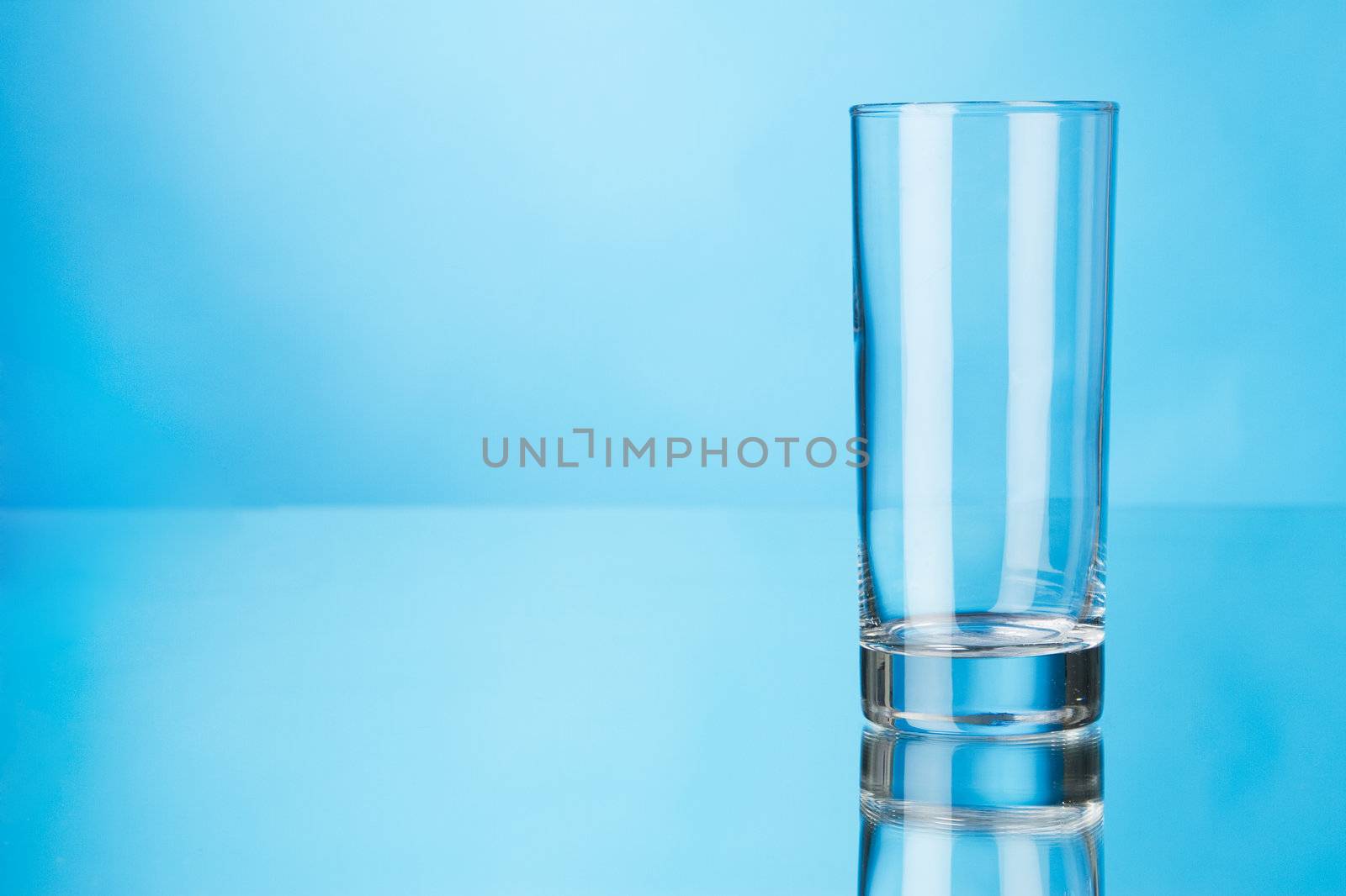 Empty glass on blue background, studio photo
