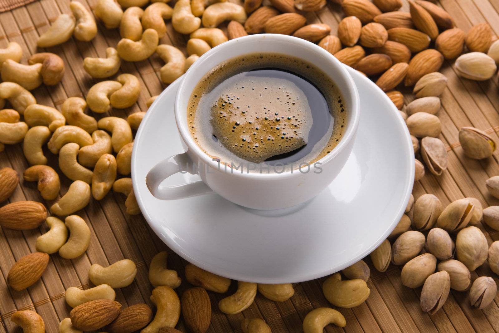 Delicious coffee with nuts on the background