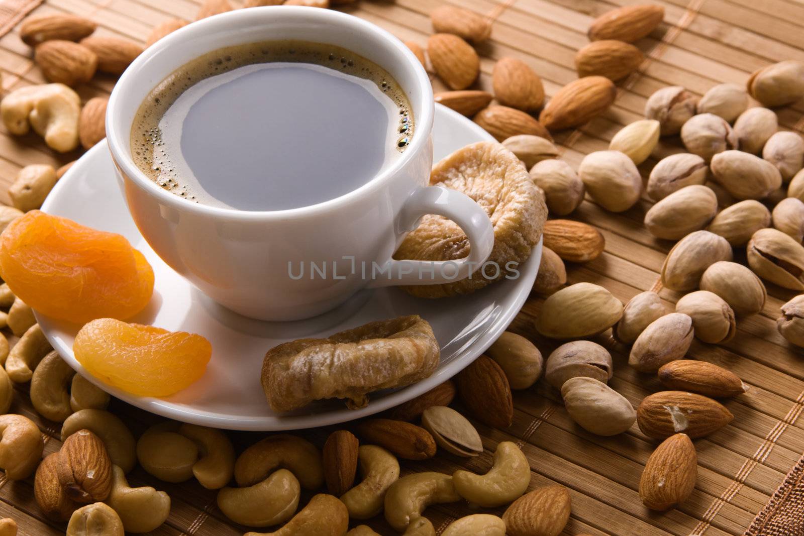 Coffee with nuts, fig and dried apricots still life