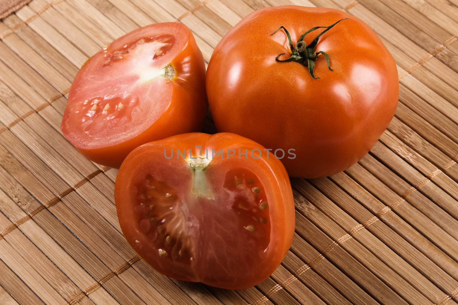 Ripe tomatoes on bamboo pad