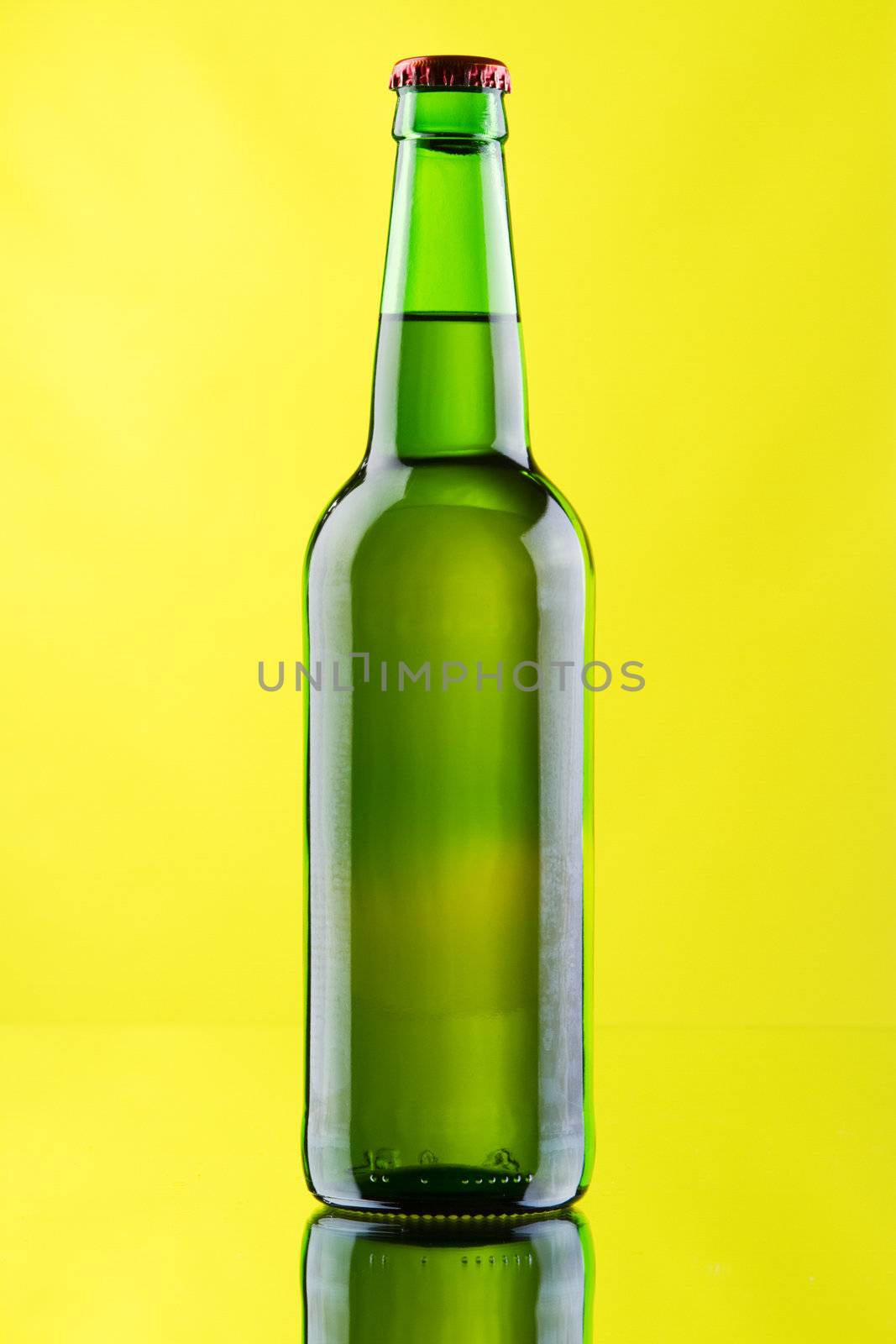 Beer mug and bottle on yellow background, studio photo