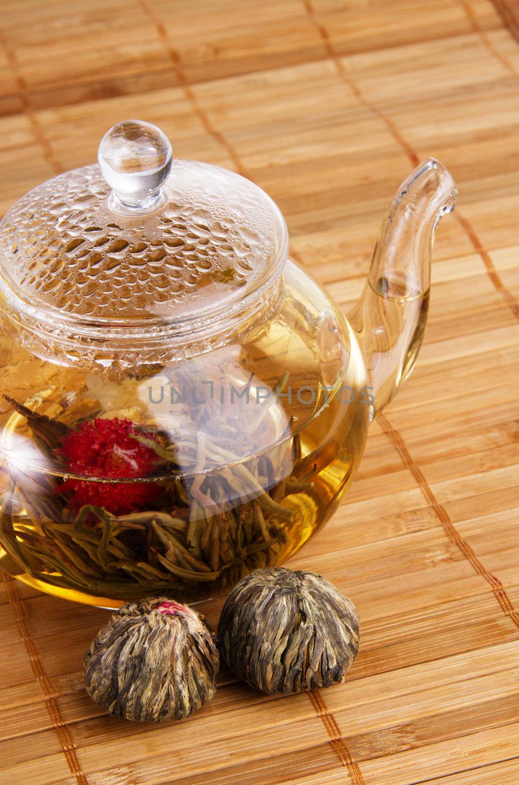 Closeup of glass teapot with fresh tea and dry tea flowers