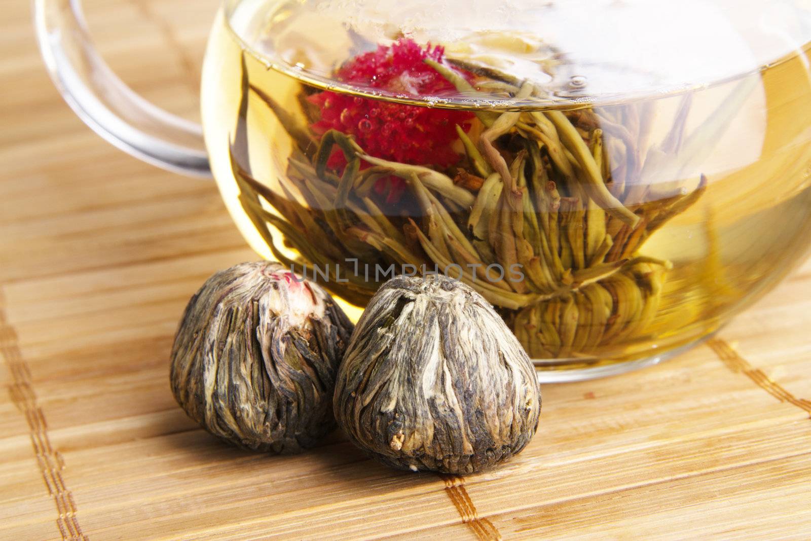 Closeup of dry flowers of white Chineese tea and glass teapot