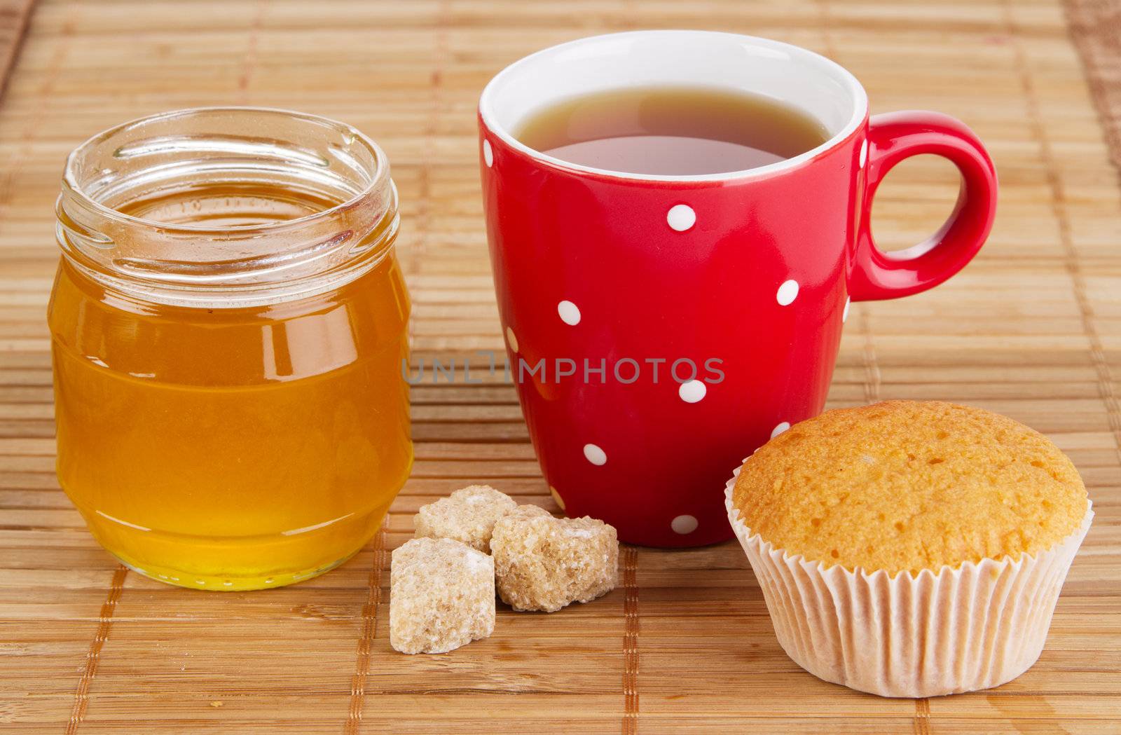 Cup of sweet tea with cakes and honey