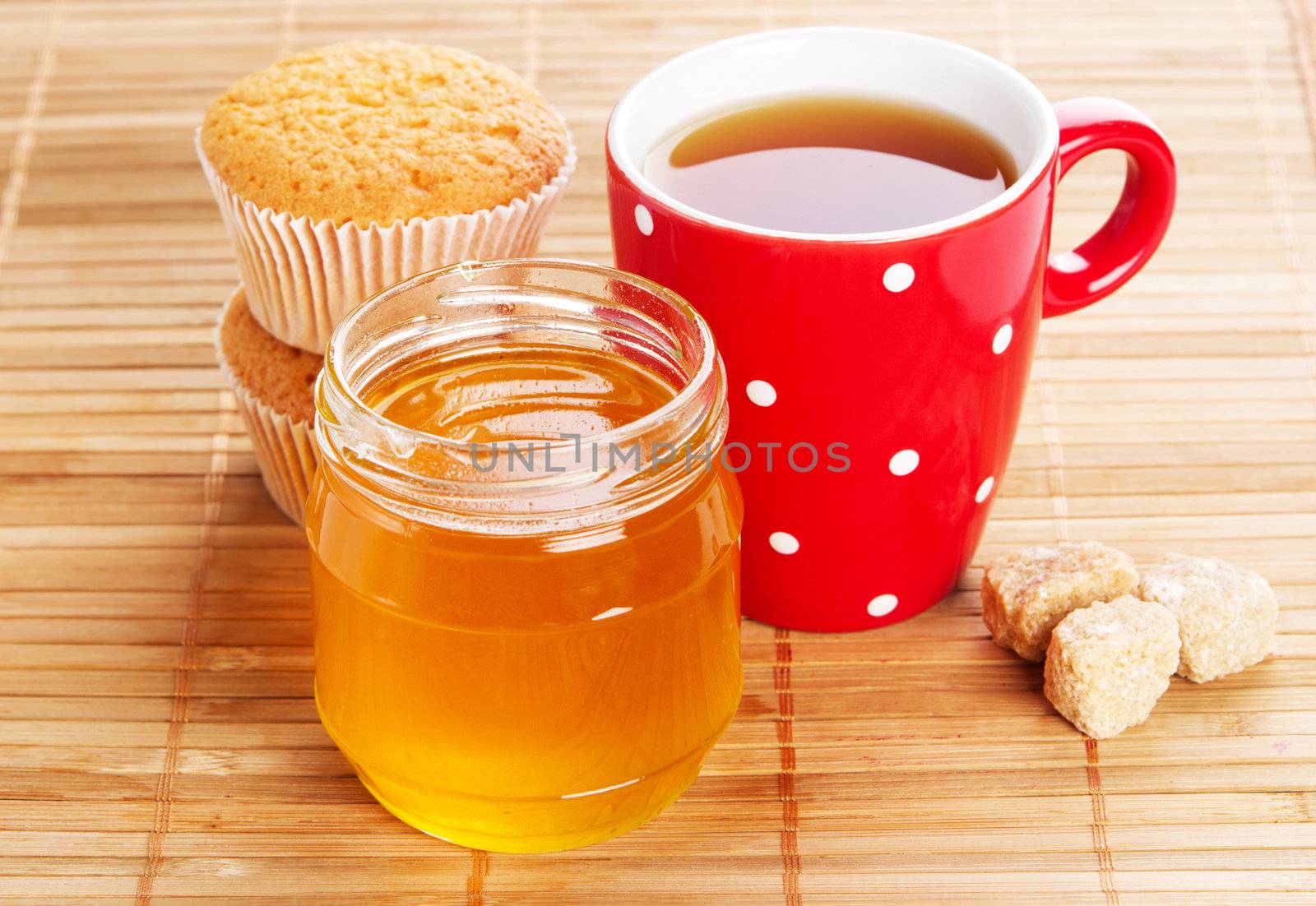 Cup of sweet tea with cakes and honey