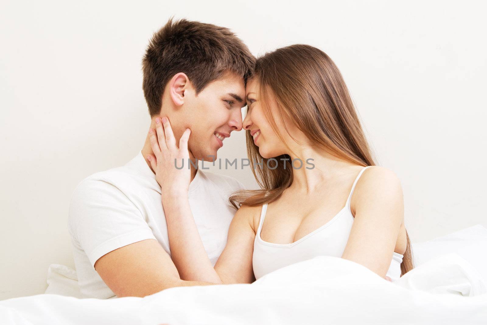 Beautiful young couple in bed, face portrait