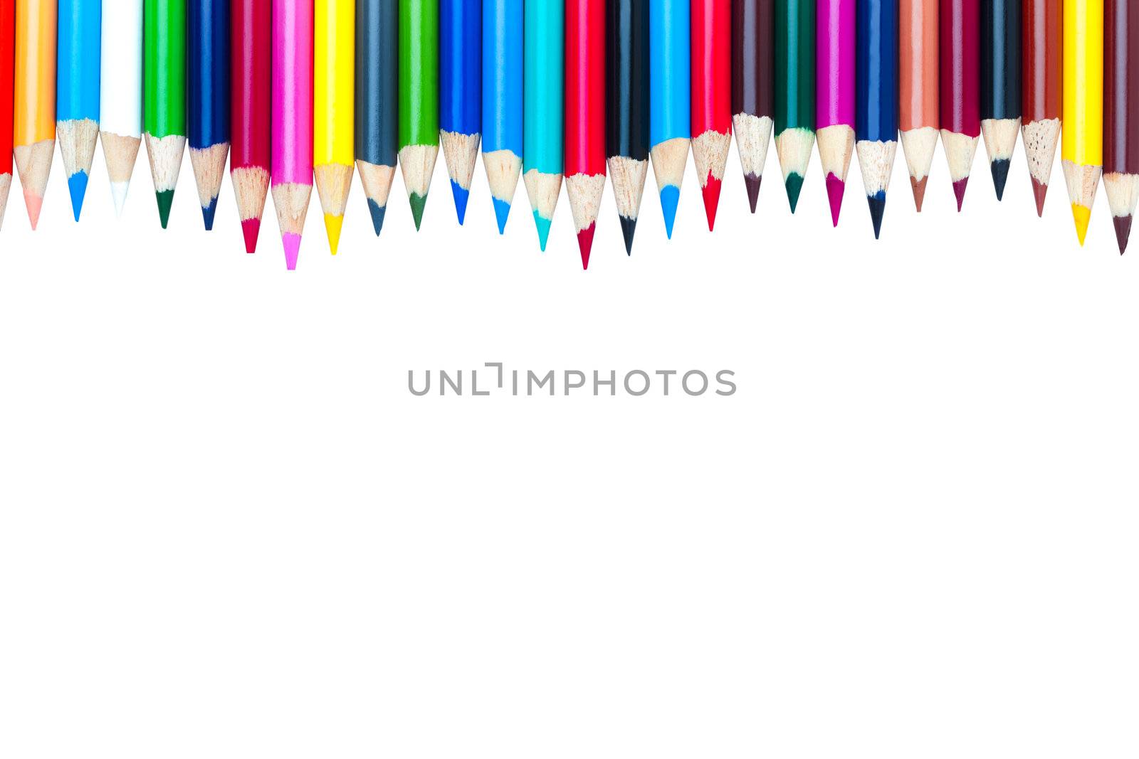 Multi-colored pencil crayons aligned in a wave arrangement isolated on a white background. 