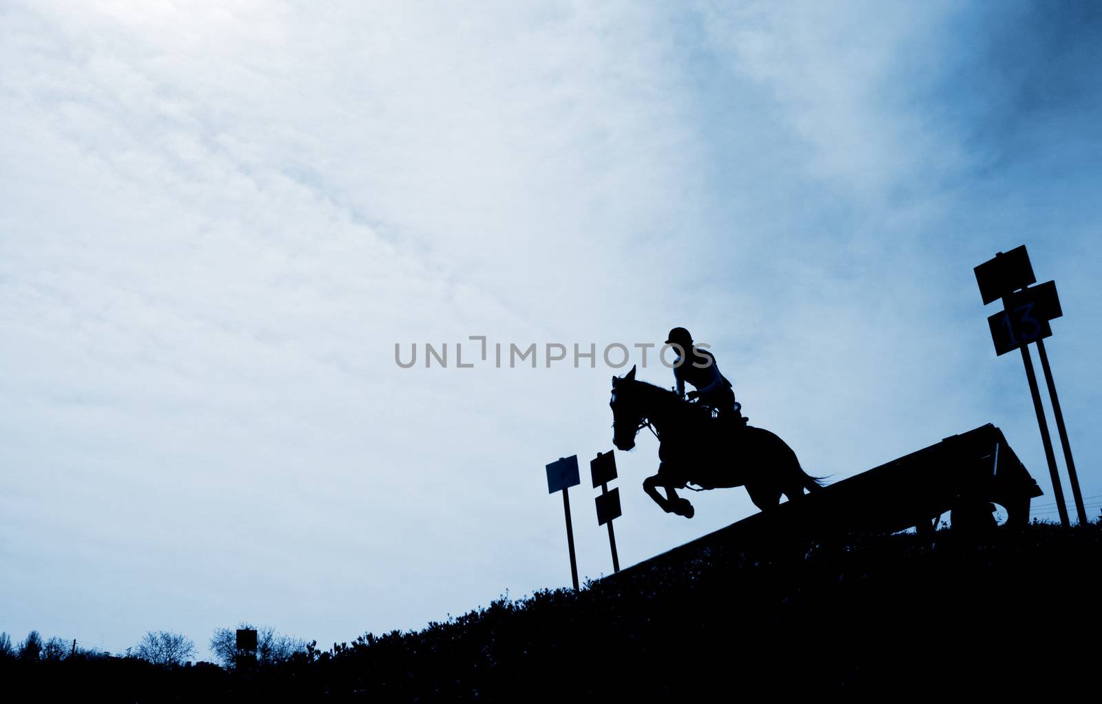 Silhouette of a horseman riding downhill