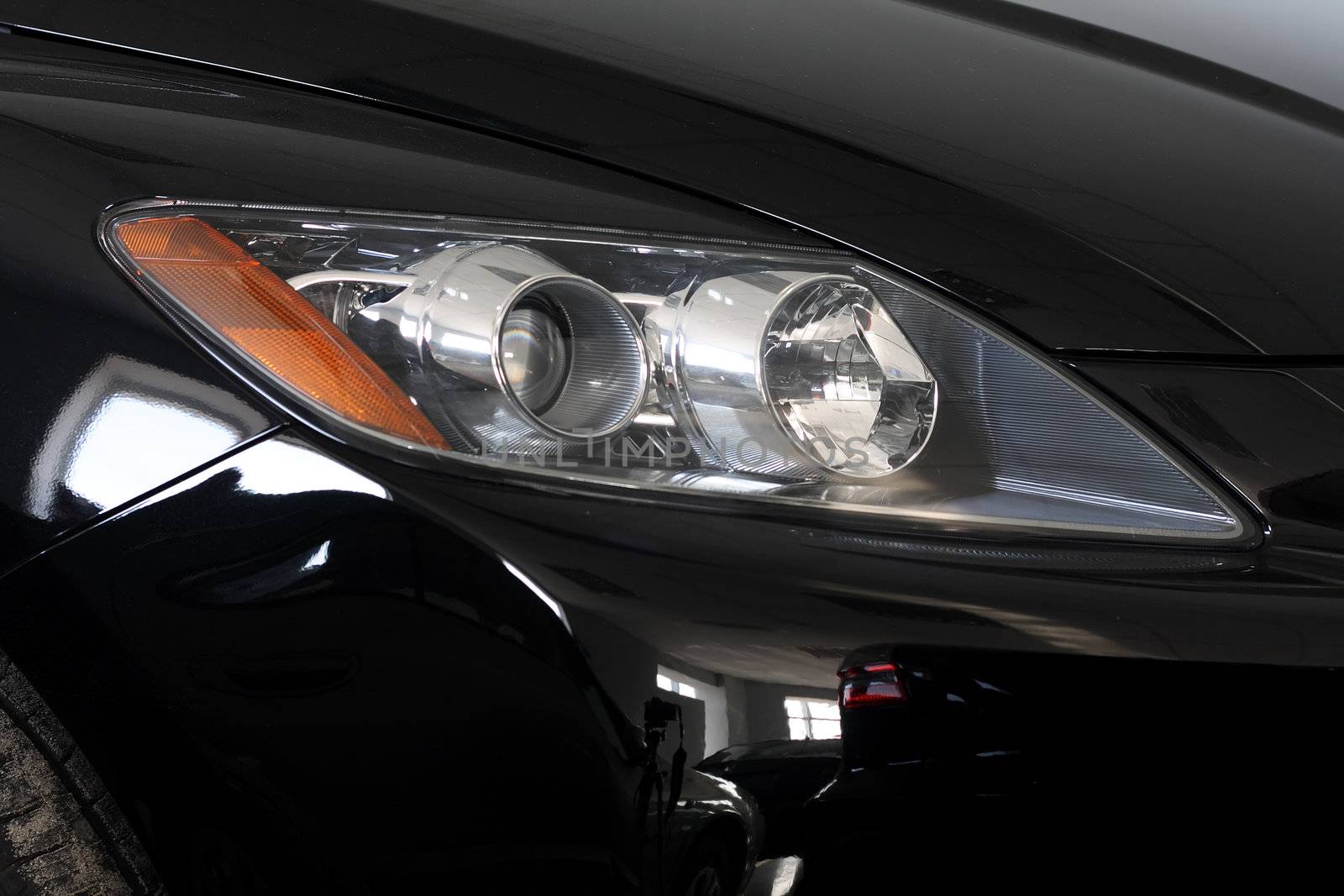 Close-up view of front lights of a black car.