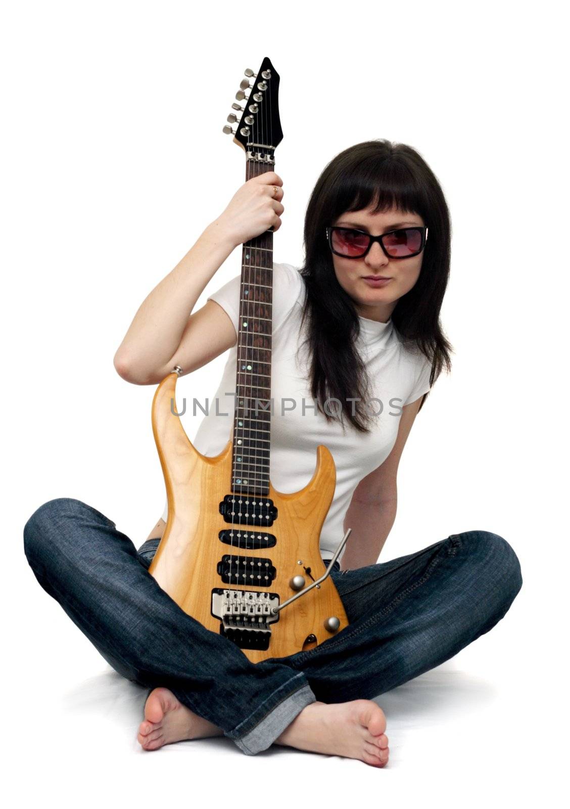 Pretty young girl sitting and holding an electric guitar