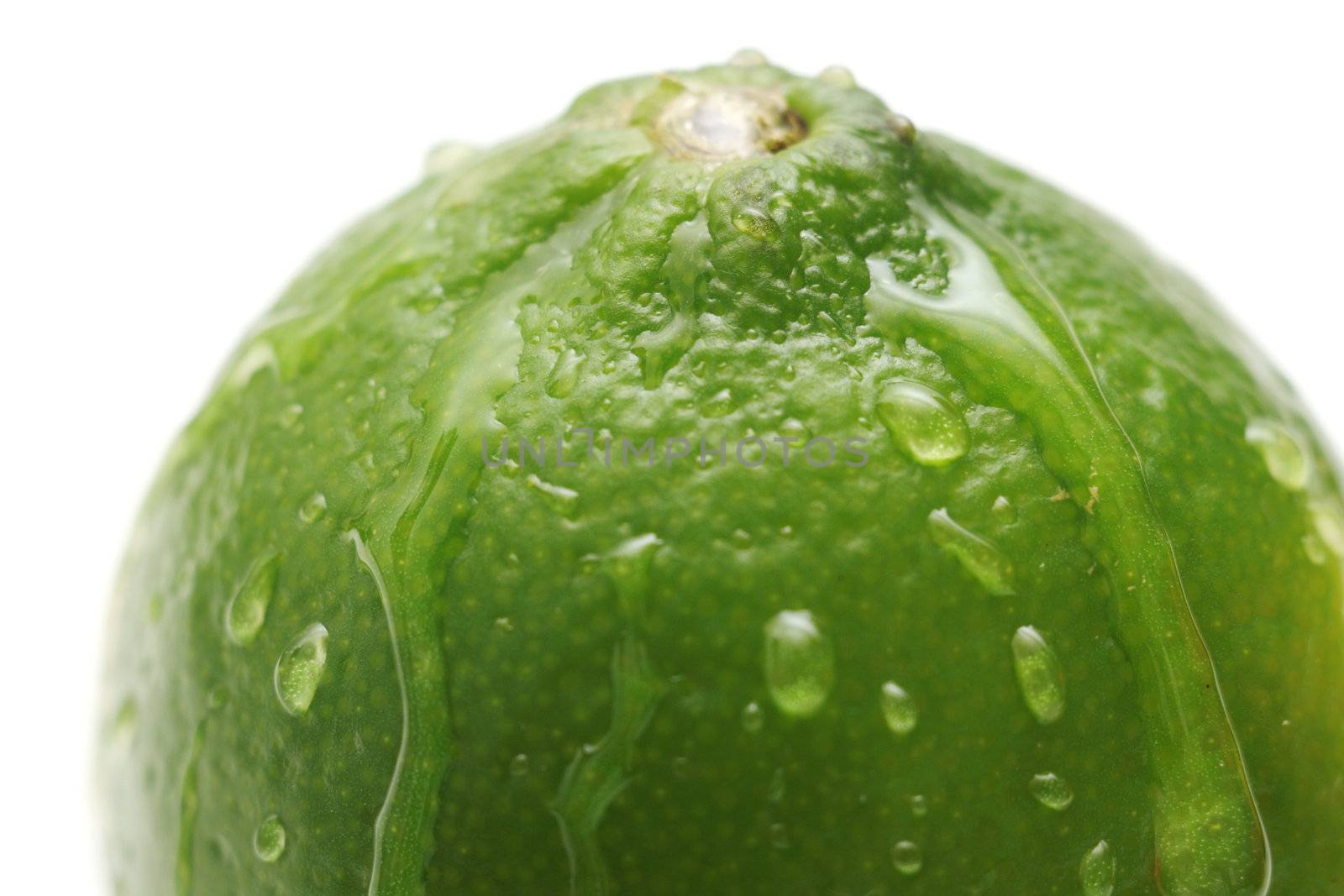 Juicy lime with waterdrops on its surface, isolated on white