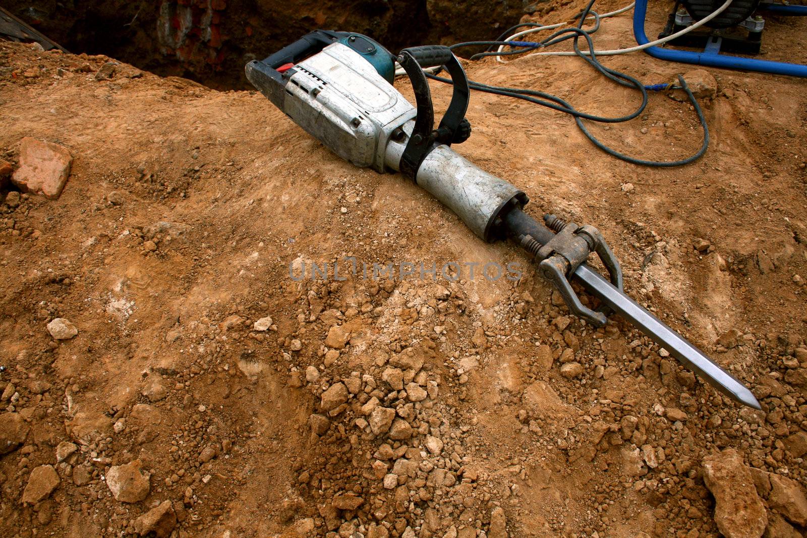 Grungy pneumatic hammer lying on the ground