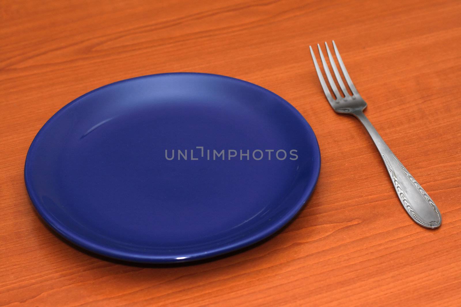 Blue empty plate with a fork