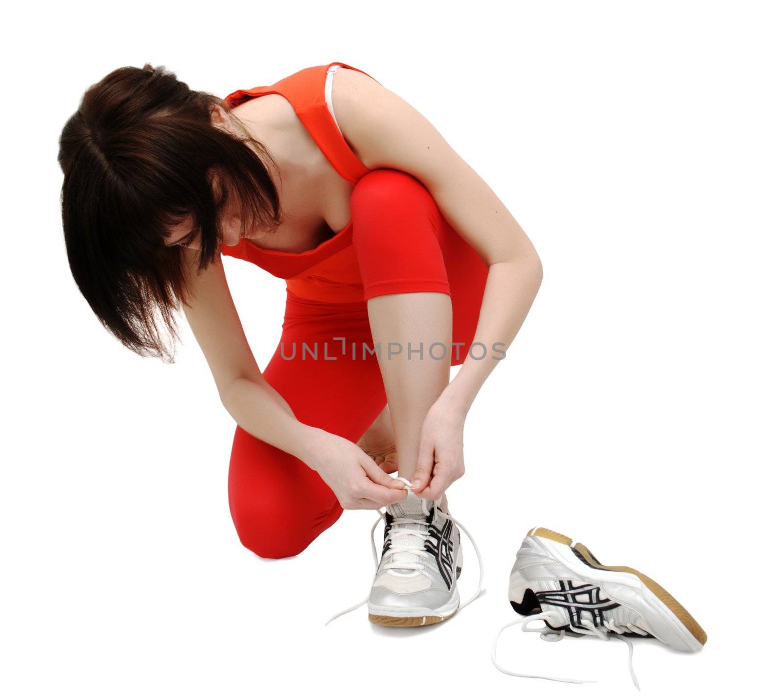 Woman tightening her jogging shoes by Gdolgikh