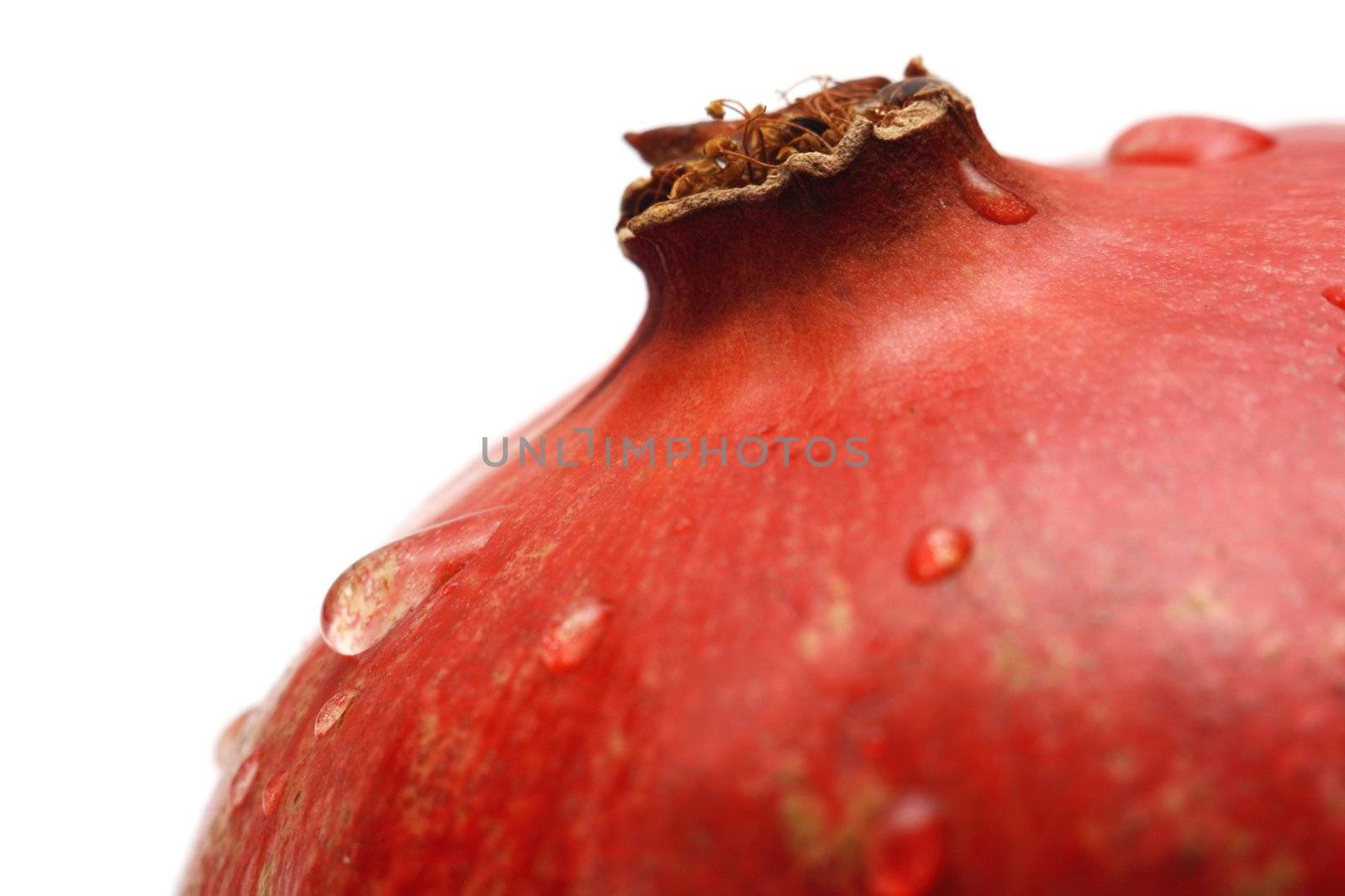 Pomegranate with waterdrops on its surface